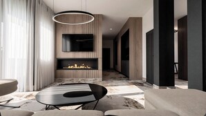 A modern living room with a fireplace, a flat-screen TV, and a dining area. - Hotel Galaxy Timisoara, A Member Of Radisson Individuals (Timisoara)