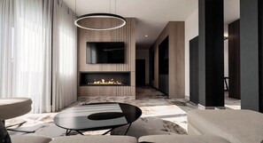 A modern living room with a fireplace, a flat-screen TV, and a dining area. - Hotel Galaxy Timisoara, A Member Of Radisson Individuals (Timisoara)