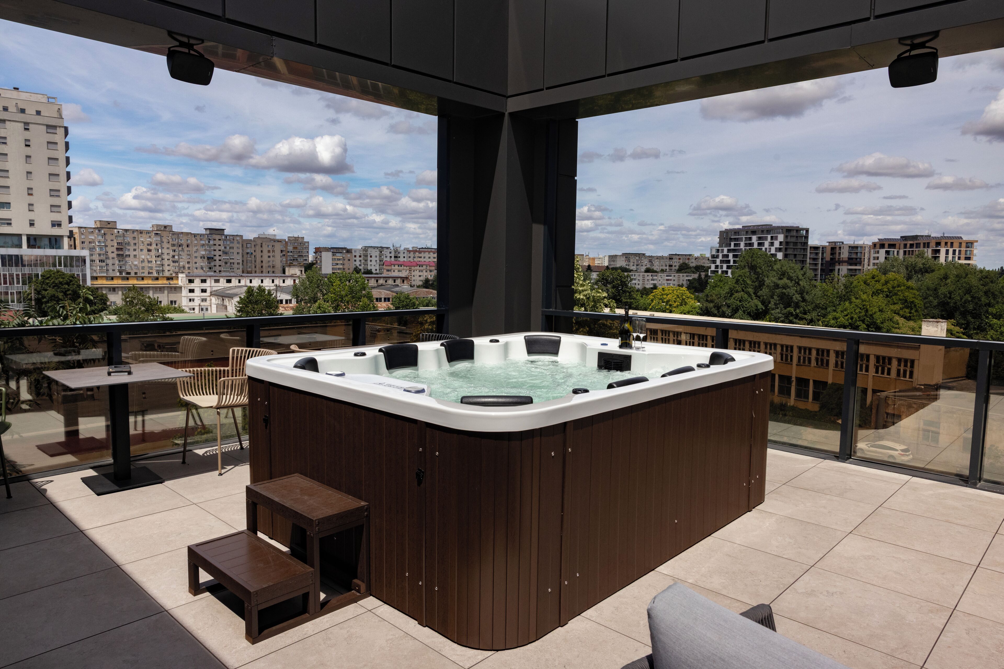 A hot tub on a balcony with a city view.