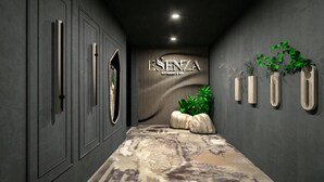 A hallway with a patterned carpet, a wall-mounted sign reading 'ESTENZA RESTAURANT & BAR', vertical slats, and potted plants. - Hotel Galaxy Timisoara, A Member Of Radisson Individuals (Timisoara)