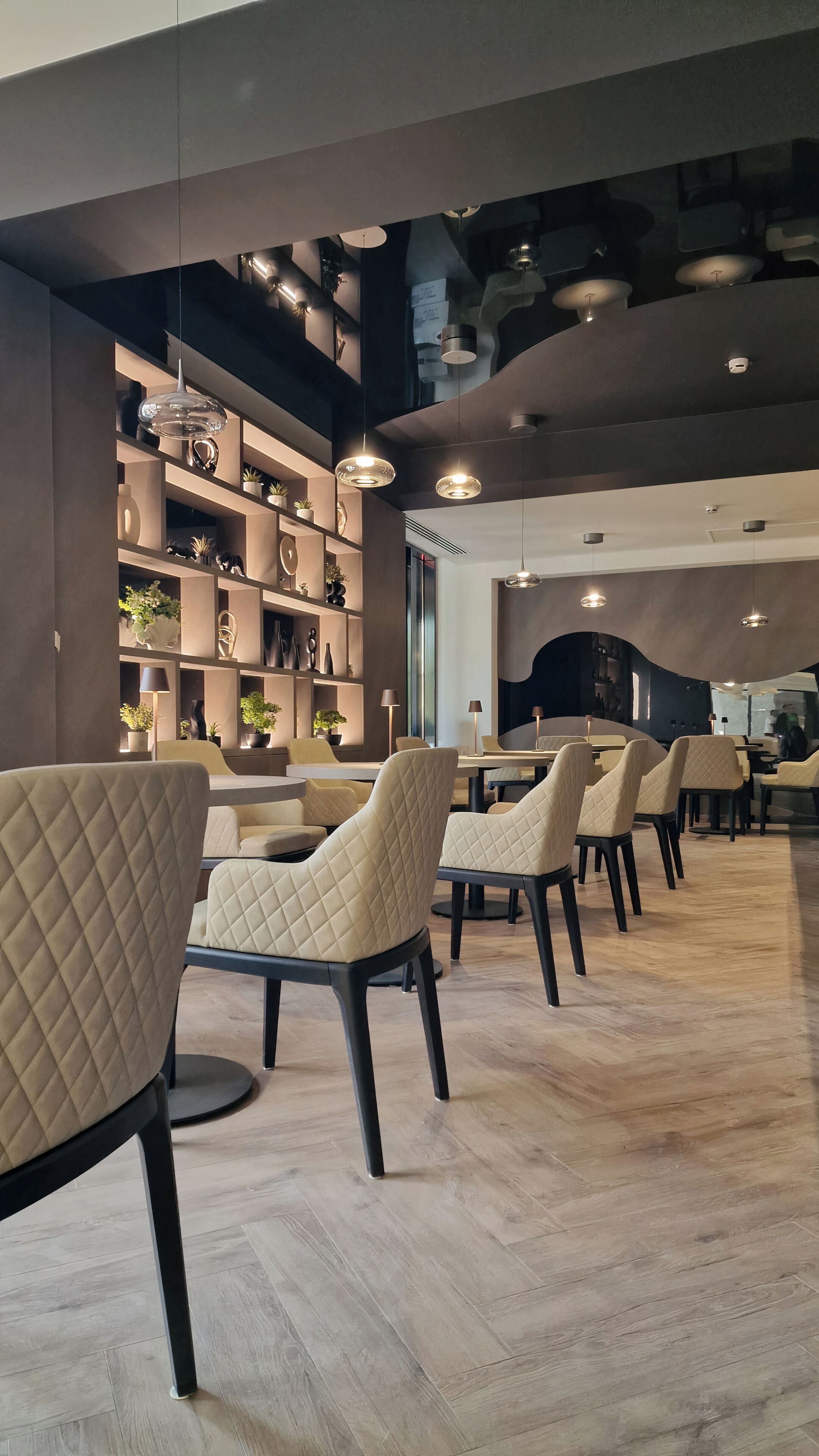 A modern interior with seating, pendant lighting, and a wooden floor.