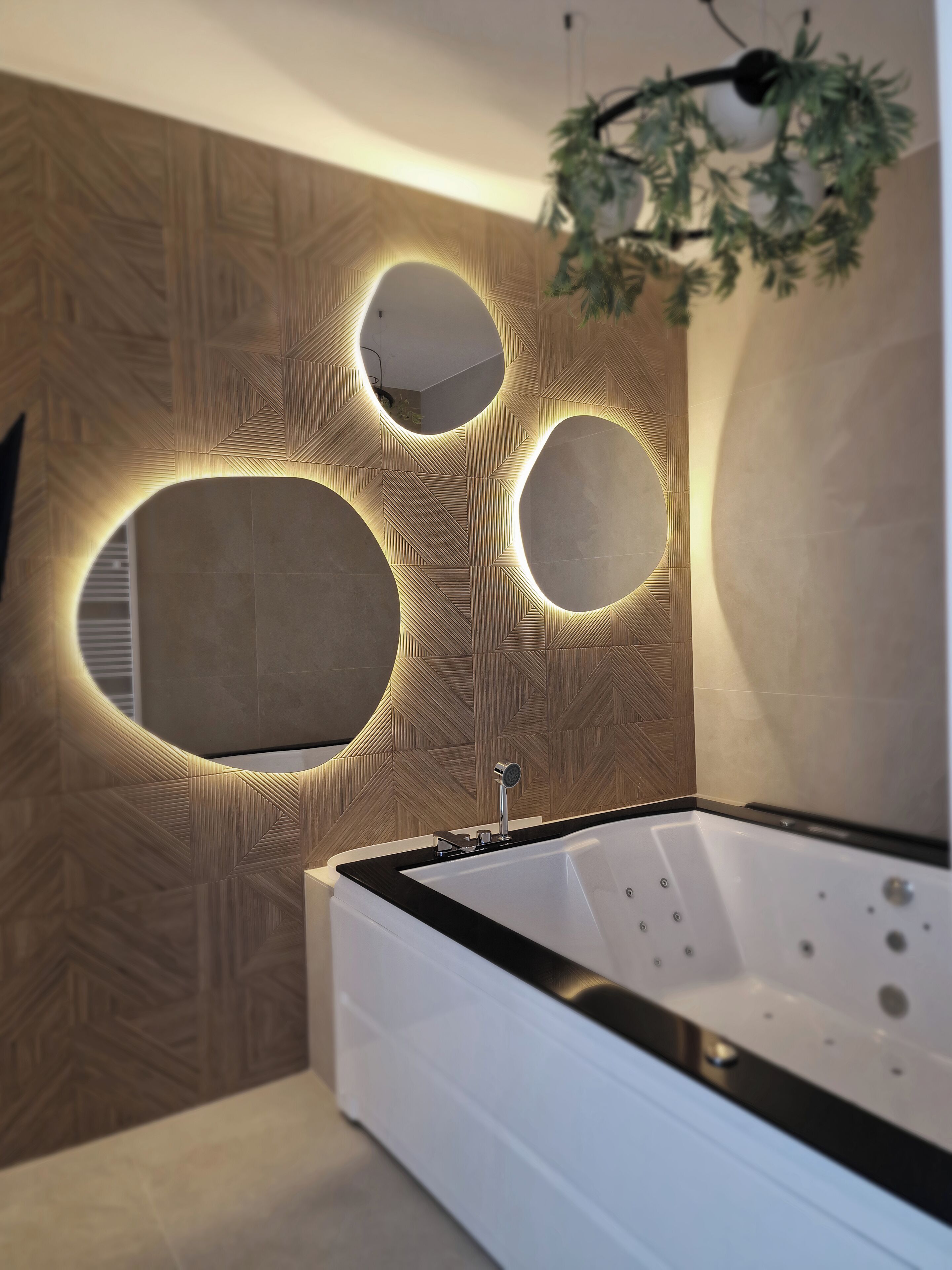 A modern bathroom with a freestanding bathtub, wall-mounted circular mirrors, and a geometric patterned wall.