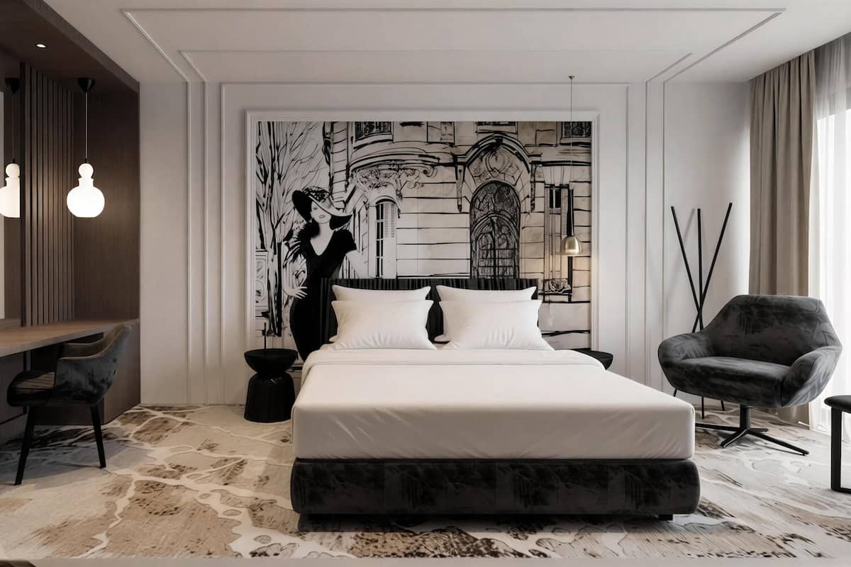 A modern hotel room with a large bed, a desk, a chair, and a wall mural.