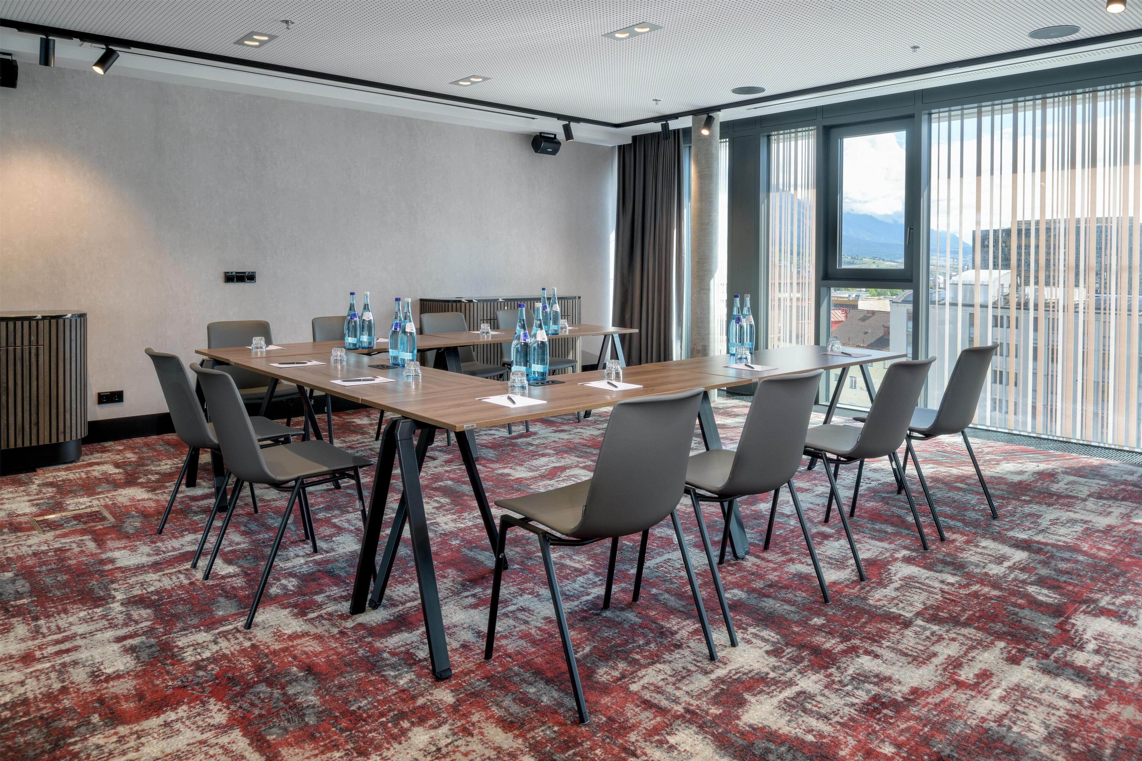 A conference room with a long table, six chairs, and water bottles.