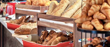 A buffet with various breads and pastries.