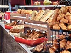 A buffet with various breads and pastries.