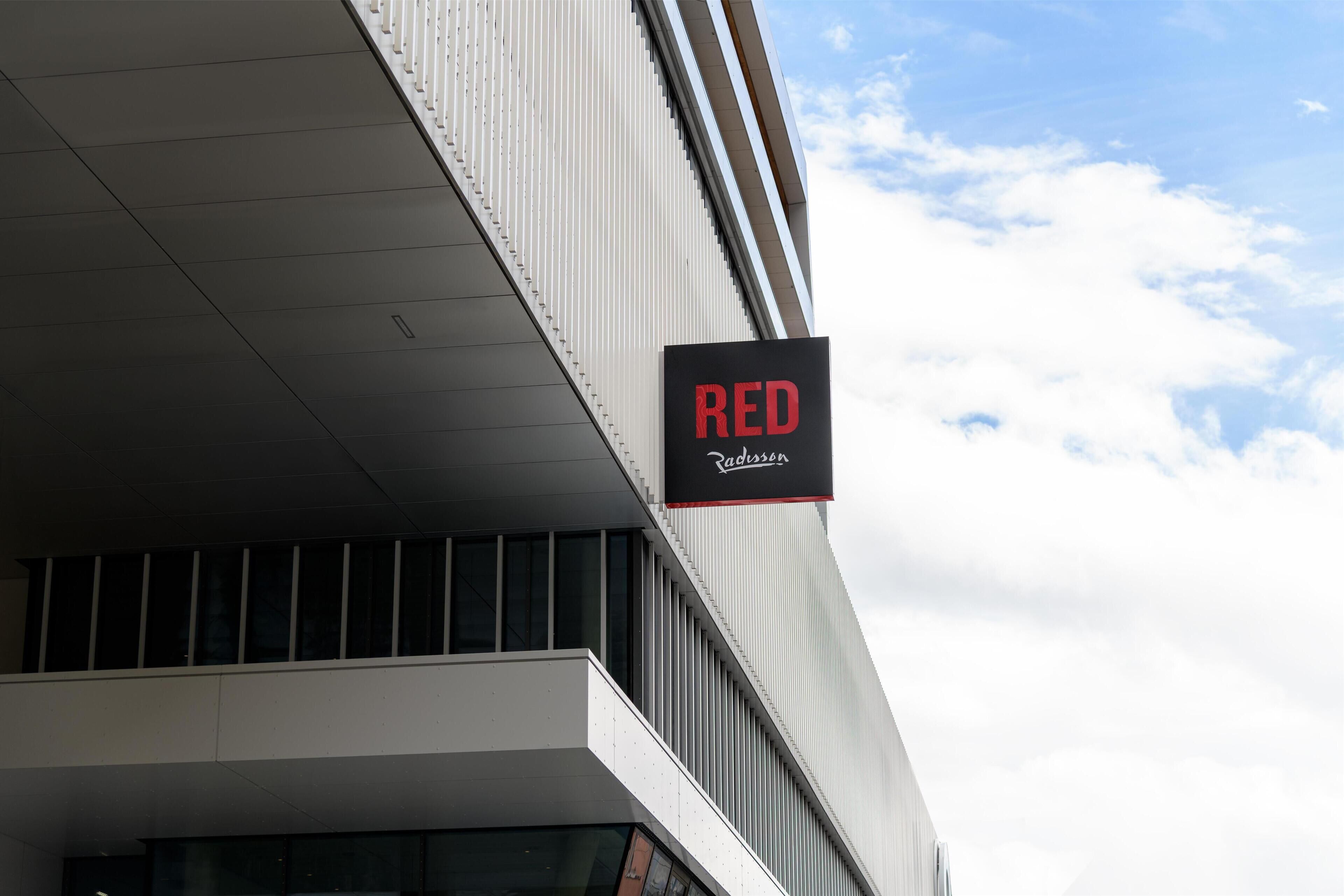A building with a modern architectural style, featuring a prominent 'RED' sign.