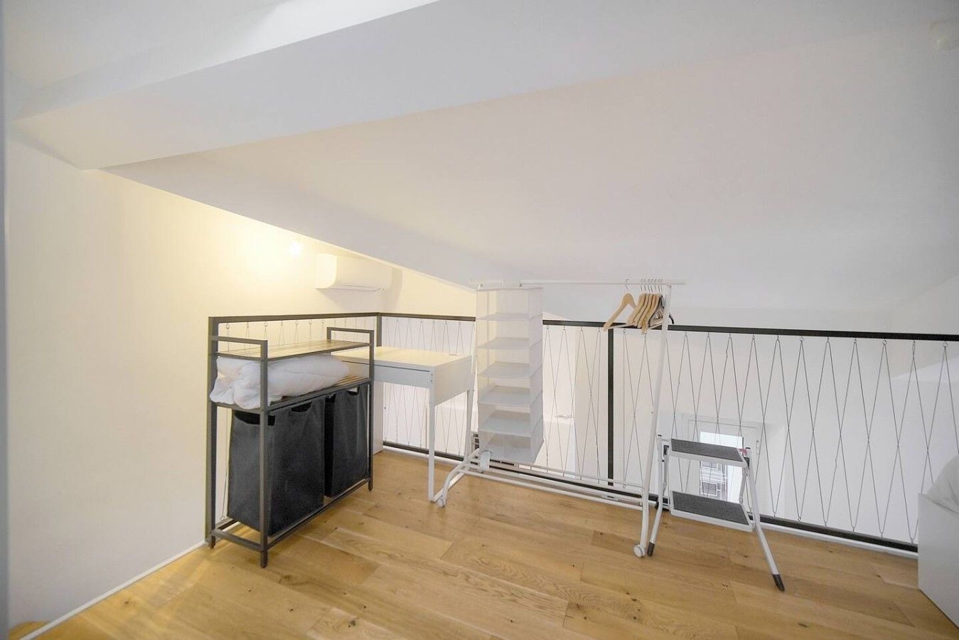 A small, well-lit room with a bunk bed, a desk, and a chair.