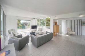 A modern living room with a grey sofa set, a flat-screen TV, and a wooden cabinet. - FRGK Villa Hameau des Collines Pool, Tranquil (Le Cannet)