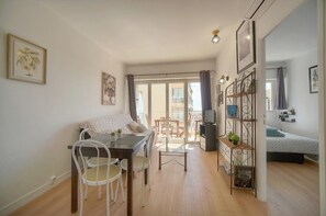 A compact living space with a dining area, a sofa, a TV, and a balcony. - Frgk Fauvettes Terrace Parking, Air Conditioning, UltraFast Wi-Fi (Cannes)