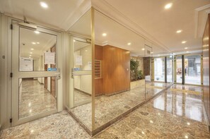 A hotel lobby with glass doors, a reception desk, and a marble floor. - One-bedroom apartment in Cannes, France (Cannes)