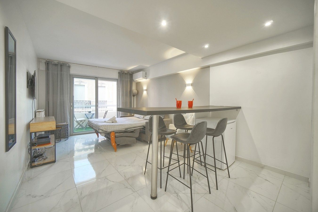 A modern apartment with a kitchen, dining area, and a balcony.
