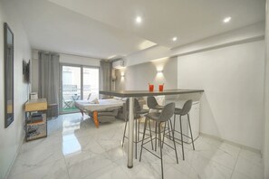 Eine moderne Wohnung mit Küche, Essbereich und einem Balkon.