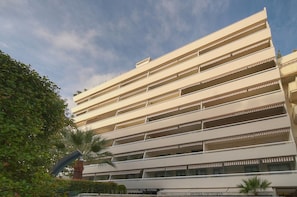 Un hotel a più piani con balconi su ogni piano, un bar e una zona piscina.