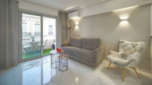 Ein modernes Wohnzimmer mit einer Couch, einem Sessel und einem kleinen Tisch mit einer Zeitschrift.