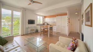 A modern apartment with a dining area, kitchen, and living room. - FRGK Isola Bella Comfortable apartment (Cannes)