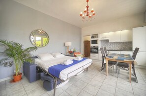 A modern bedroom with a bed, bedside table, and a potted plant. - Question: "Breathtaking Ocean Views in Villefranche" (Villefranche-sur-Mer)