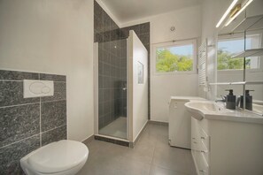 A modern bathroom with a shower, toilet, and sink. - Question: "Breathtaking Ocean Views in Villefranche" (Villefranche-sur-Mer)