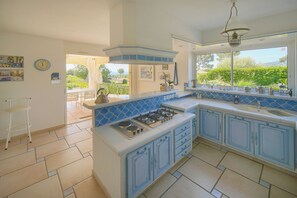 A kitchen with a gas stove, a sink, and a window overlooking a garden. - FRGK "Villa Claude - Juans les Pins (Antibes)
