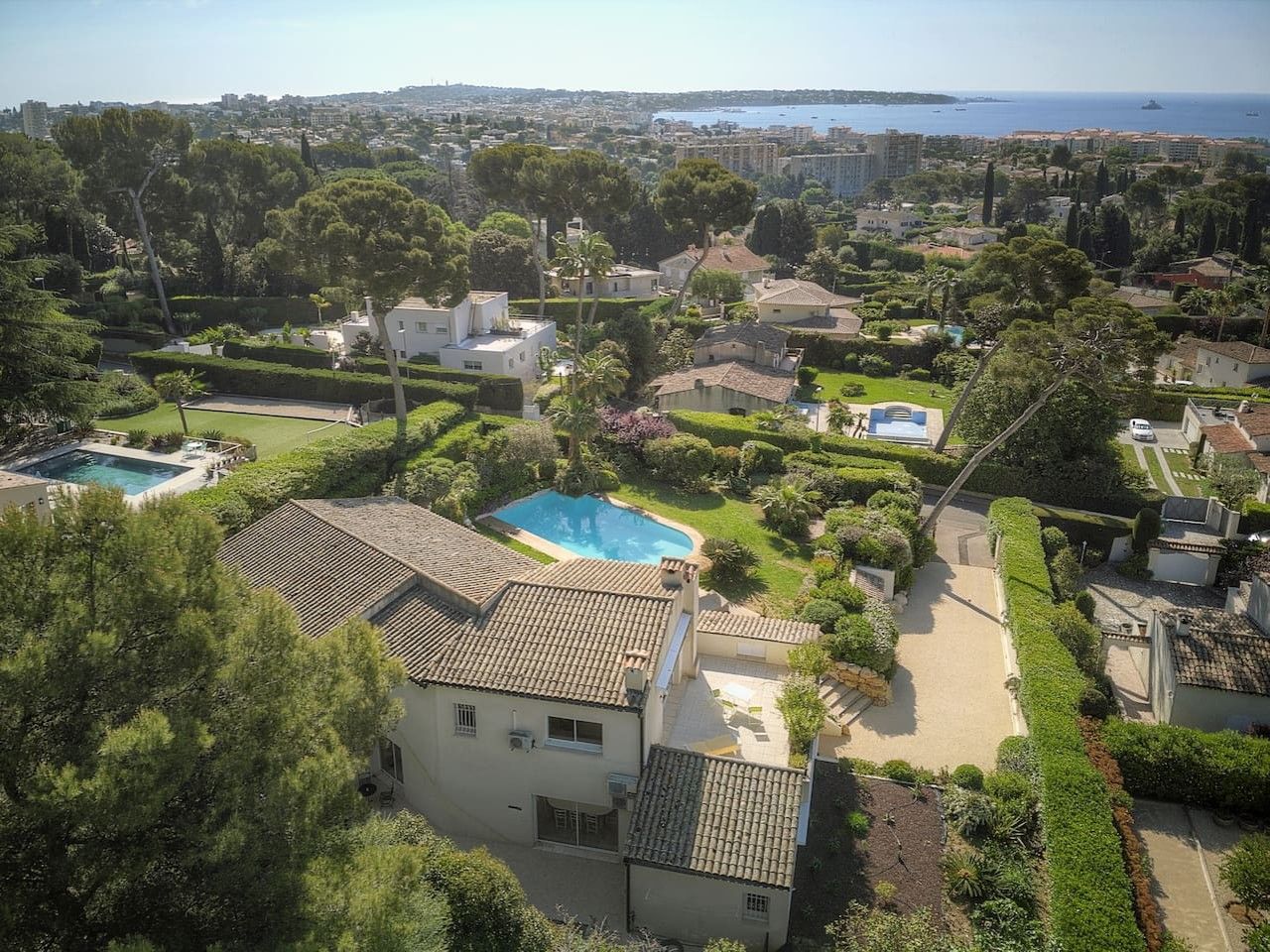Zona residencial con piscina, casas adosadas y vista al mar.