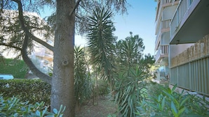 Un cortile con un albero, un vialetto e un edificio con balconi.