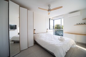 A bedroom with a bed, a ceiling fan, a window, and a TV. - One-bedroom apartment in Antibes, France (Antibes)
