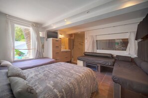A bedroom with two beds, a TV, a desk, and a window overlooking a pool. - Nine-bedroom home in France, Antibes (Antibes)