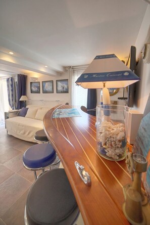 A room with a wooden bar, a bed, a seating area, and a wall-mounted TV. - Nine-bedroom home in France, Antibes (Antibes)