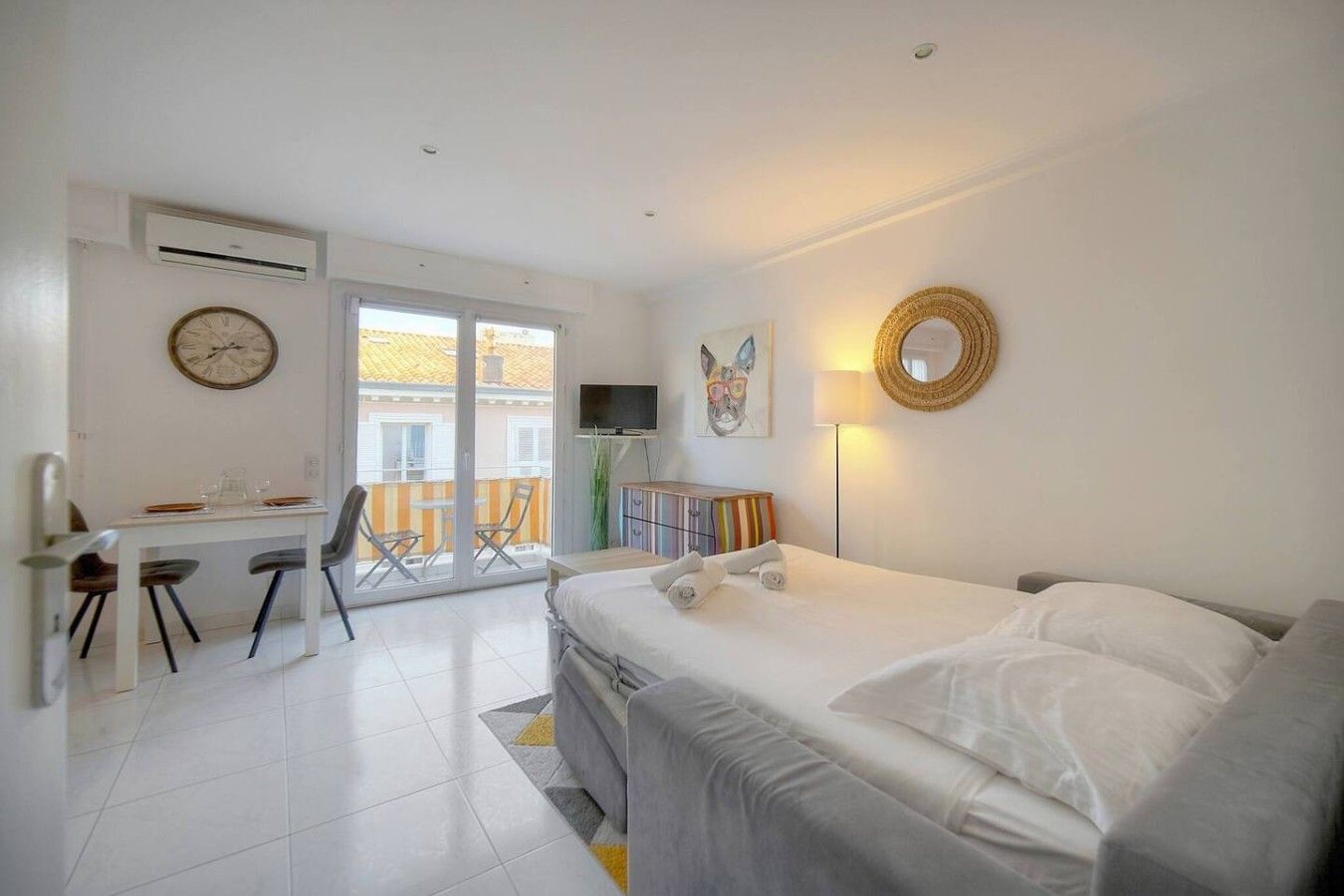 Ein Hotelzimmer mit Bett, Schreibtisch, Stuhl, Fernseher und einem Balkon mit Blick.
