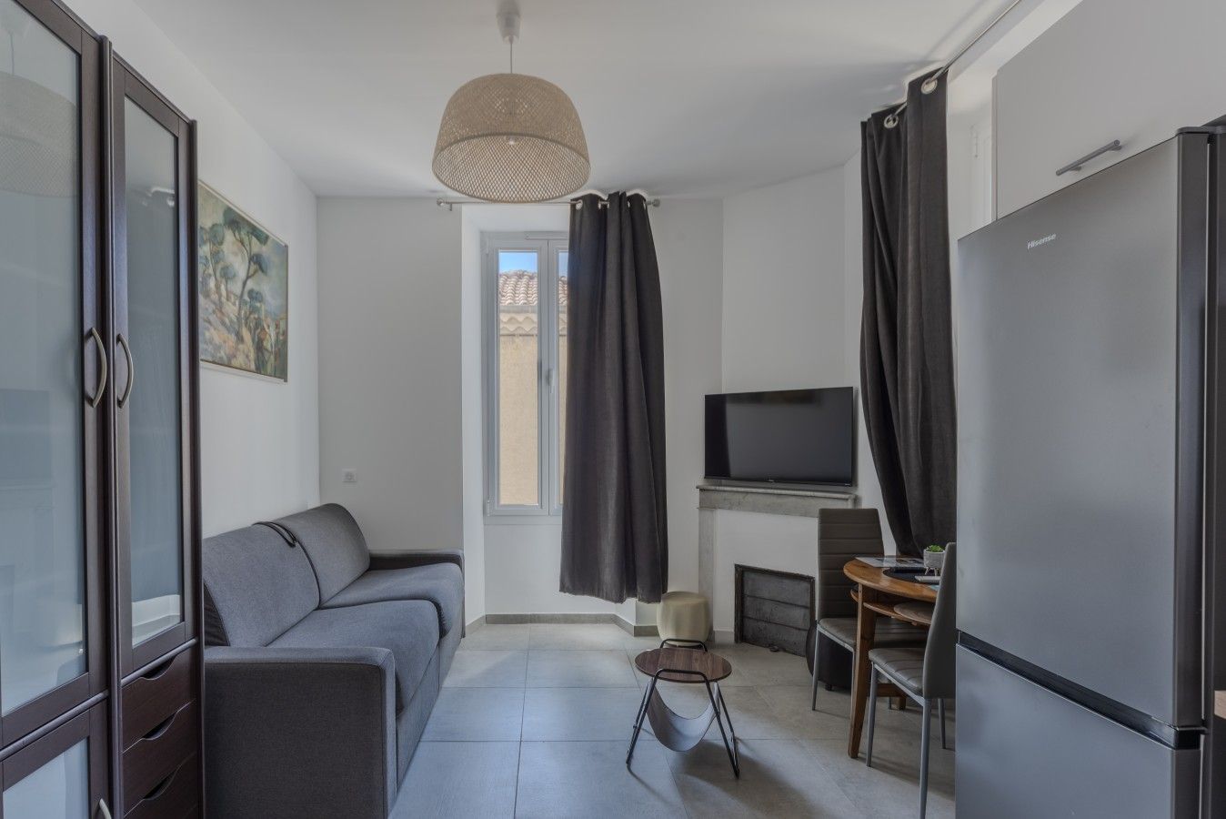 Un salon moderne comprenant un canapé, un téléviseur, une cheminée et un réfrigérateur.