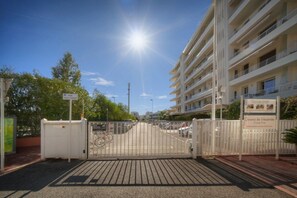 A gated entrance to a multi-story building with a clear sky and sunlight. - FRGK - Copacabana Palm Beach Studio (Cannes)
