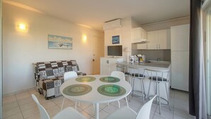 Un espace de vie compact comprenant un coin repas, une kitchenette et un canapé.