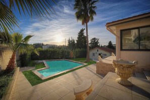 A swimming pool with a tiled deck, a stone planter, and a view of the cityscape. - FRGK Contemporary Villa StudioIndependent Pool (Le Cannet)