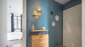 Ein Zimmer mit einem Bett, einem Holzschrank, einer Wand mit Dekoration und einer Tür.