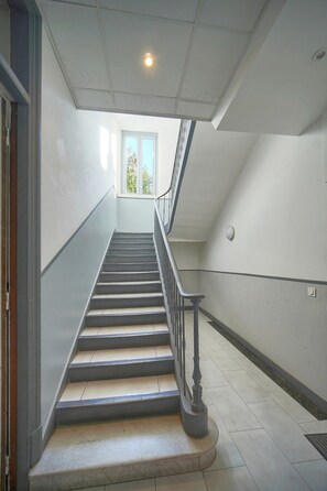 Eine Treppe mit Handlauf, die zu einer Zwischenebene führt.