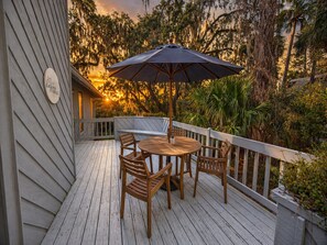 A wooden deck with a table and chairs, surrounded by a railing, and a large umbrella. - Deer Run Hideaway - Game Room (Johns Island)