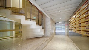 Ein modernes Interieur mit Treppe, Glastrennwand und einer Reihe von Aufbewahrungsboxen.