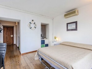 Ein Schlafzimmer mit Bett, Schreibtisch, Stuhl, Kleiderschrank und einer Tür.
