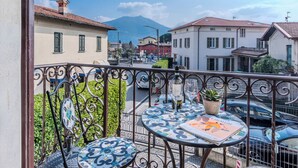 A balcony with a view of a street, a mountain, and buildings. - Casa Luvit by Interhome (Menaggio)