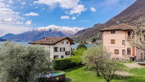 A lakeside property with a swimming pool, a tennis court, and a mountain backdrop. - Onda Blu by Interhome (Gera Lario)