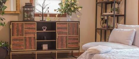 A bedroom with a bed, a wooden cabinet, a ceiling fan, and a window with blinds.