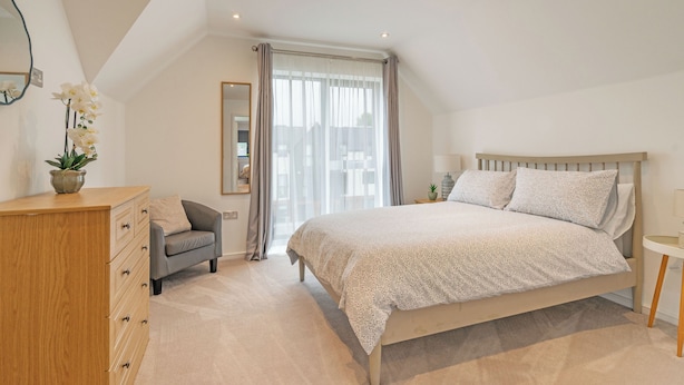 A bedroom with a bed, a dresser, a chair, a bedside table, and a window with curtains. - HH 120m2 | Fast wi-fi | Work | Holiday |BBQ | Pet (Tonbridge)