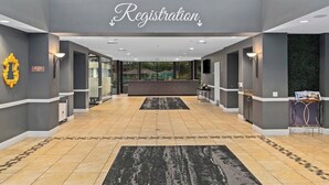 Un espace d’accueil avec un comptoir de réception, une enseigne au-dessus et un tapis à motifs.