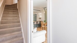 Een tapijtsgewaden trap die leidt naar een eethoek met een houten tafel en stoelen.