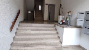 A staircase leading to a landing with a small rug at the bottom. - Air-conditioned apartment with balcony, wifi, near ramparts (Avignon)
