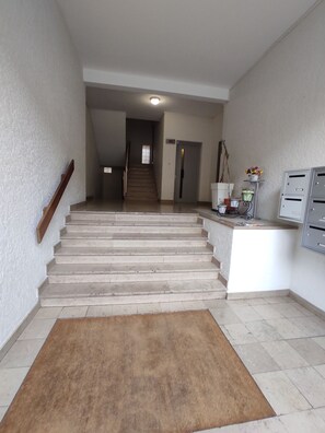 Eine Treppe führt zu einer Zwischenebene, am Fußende liegt ein kleiner Teppich.
