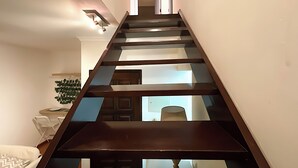 Un escalier moderne avec des éléments en bois, menant à l’étage supérieur.