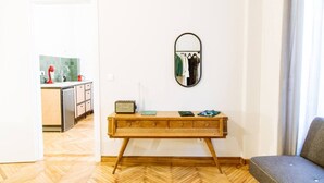Ein Zimmer mit einer Holzbänkl, einem Spiegel und einem Sofa.