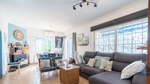 Un salon comprenant un canapé, une table basse et une cheminée. On y trouve également un coin repas avec une table et des chaises.