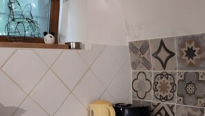 Een keuken met een vaatwasser, oven en een rode kast.